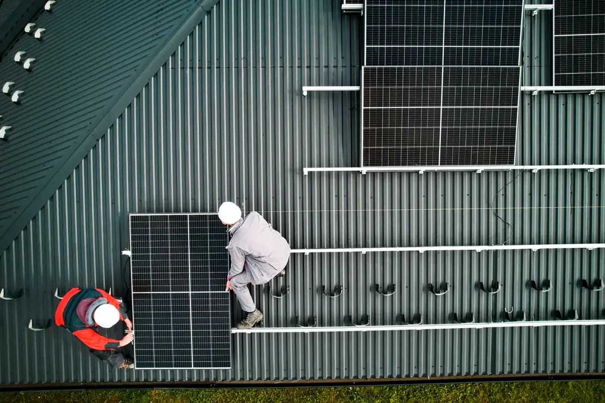 Instaladores montando paneles solares en una cubierta de Guadalajara: el precio depende de la potencia